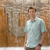 Grad student Alex Farley poses in a light blue shirt