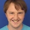 Headshot of Sam in a light blue tshirt