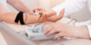 Stock image showing a patient's hands connected to a medical scanner