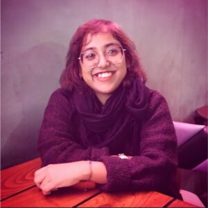Ritaja Das smiles at the camera while posing at a table